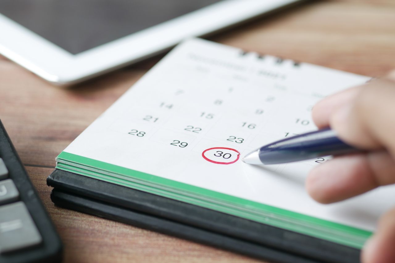 Hand markeert datum op kalender — Cruks-bedenktijd 8 dagen of 6 maanden minimum
