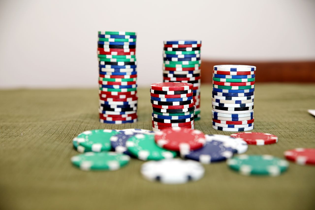 Stapels gekleurde casino-chips op groene tafel — high roller inzet NL